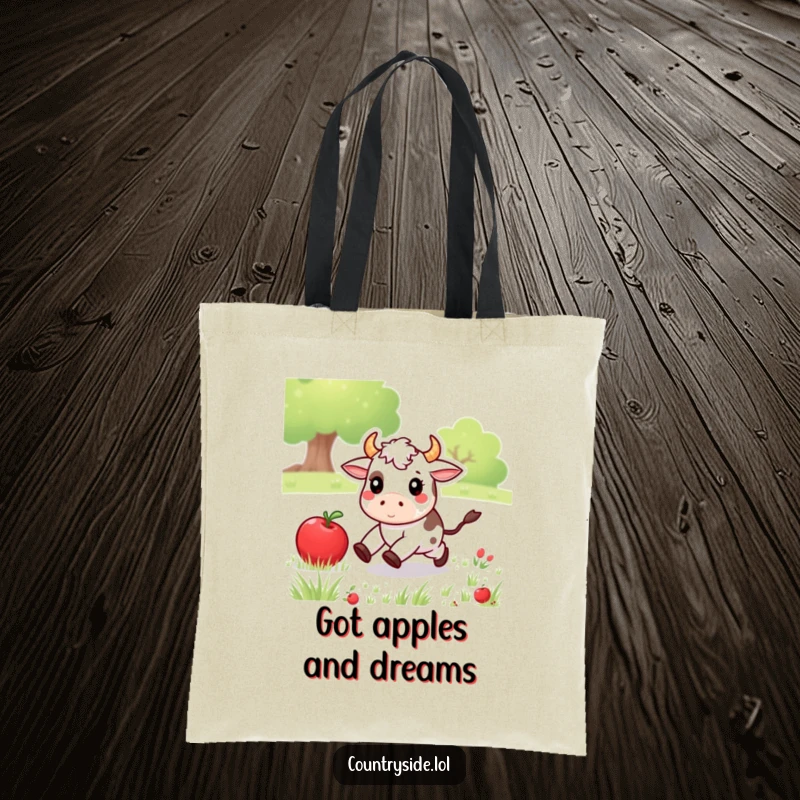 Funny Kawaii cow character gleefully chasing a rolling apple in a meadow, depicted on a durable and humorous tote bag.